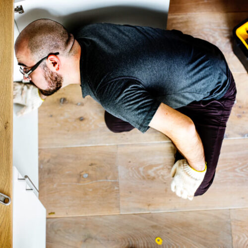 b8 Man fixing kitchen sink - image by © rawpixel